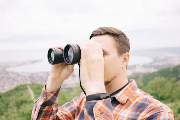 Explorador homem olhando através binóculos ao ar livre . — Fotografia de Stock
