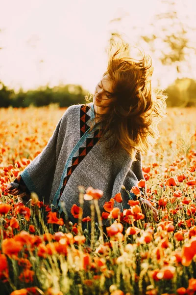 Feliz hermosa mujer relajándose en el campo de flores de amapola . —  Fotos de Stock