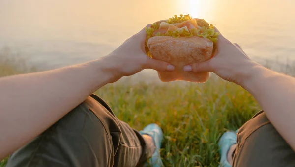 Image POV de femme avec hamburger sur le littoral . — Photo