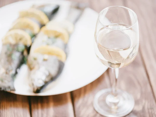 Plato de trucha de pescado y copa de vino blanco . — Foto de Stock