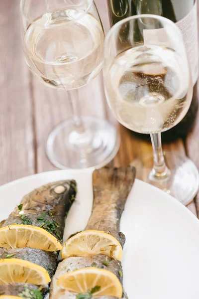 Печёная рыба и два бокала белого вина для пары . — стоковое фото