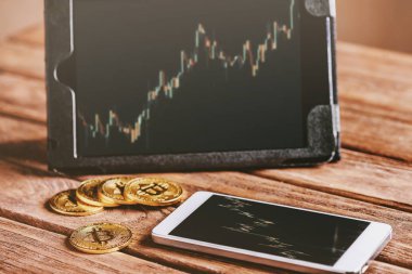 Büyüme grafiği ile dijital tablet yakınında ahşap masada Bitcoins o