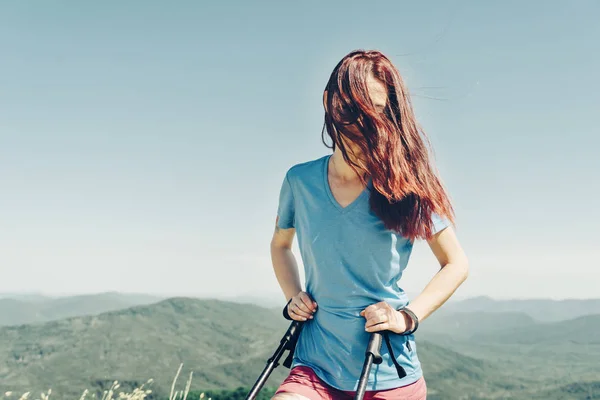 Menina desportiva andando com postes de trekking alta em montanhas de verão — Fotografia de Stock