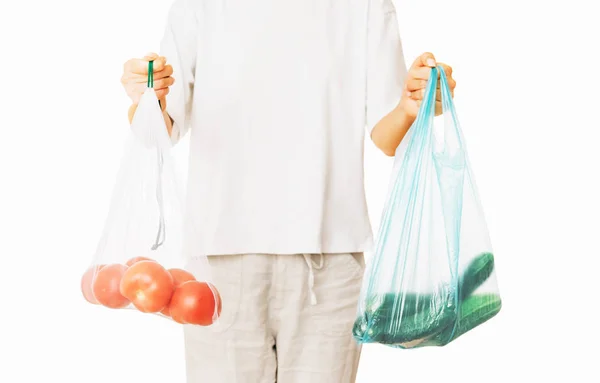 Woman holding a reusable bag and a plastic package with vegetabl — Stock Photo, Image