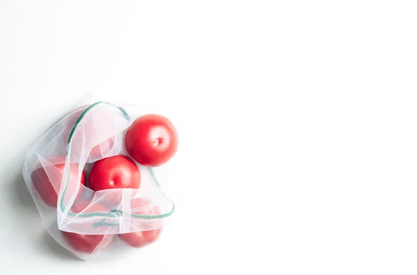 Многоразовый пакет эко-сетки со свежими помидорами . — стоковое фото