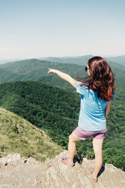 Женщина указывает на горы летом . — стоковое фото
