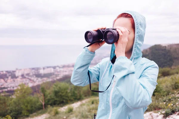 Traveler ung kvinna tittar genom kikare på sommaren utomhu — Stockfoto