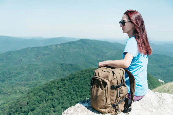 Backpacker woman sitting high in summer mountains. — Stock Photo, Image