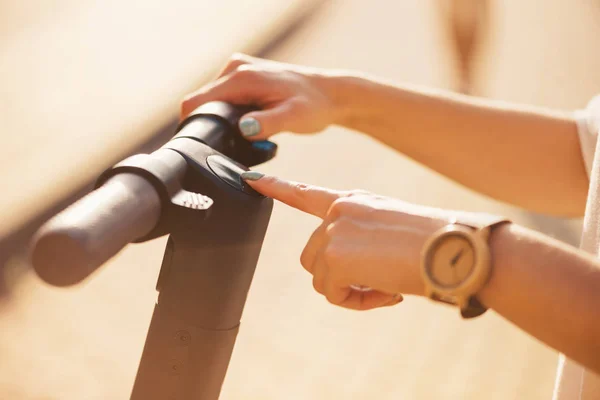 Main féminine tournant sur le scooter électrique . — Photo