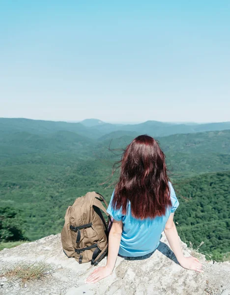 Mochilero mujer sentado en el pico del acantilado en verano . —  Fotos de Stock