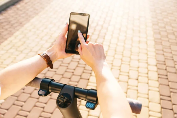 Woman standing with electric scooter and using phone, point of v — Stock Photo, Image