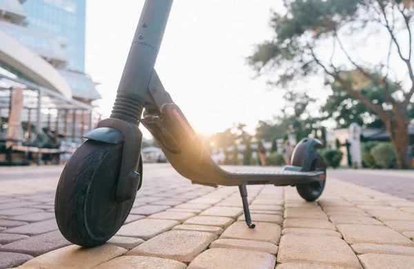 Electric scooter in city park at sunset. — Stock Photo, Image