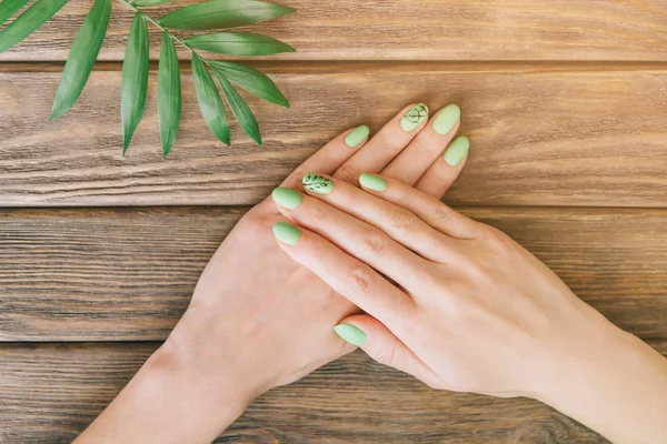 Las manos femeninas con belleza estilo de verano manicura verde . — Foto de Stock