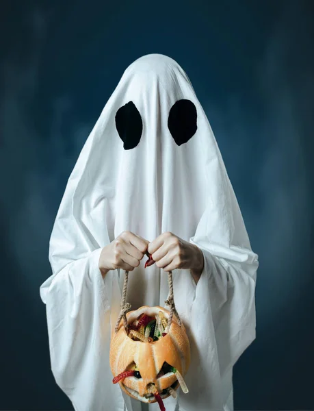 Fantasma branco segurando uma abóbora com doces . — Fotografia de Stock