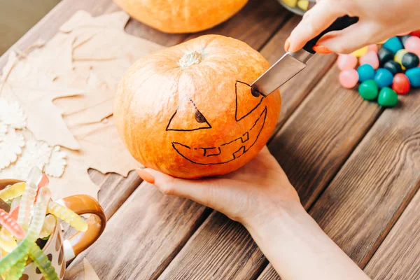 Vista de las manos femeninas tallar con cuchillo una calabaza para Halloween ho —  Fotos de Stock