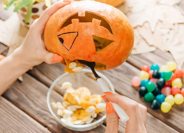 Vrouwelijke handen voorbereiding Jack-o-lantaarn pompoen voor Halloween Holi — Stockfoto