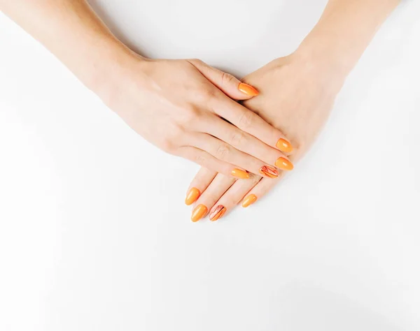 オレンジの色の専門的なマニキュアと女性の手. — ストック写真