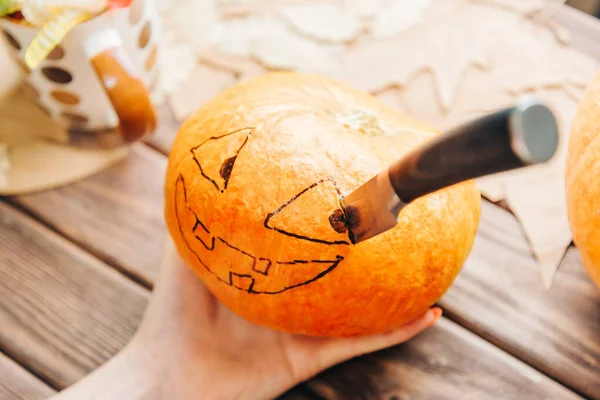 Female hand holding pumpkin with drawing Jack-o-lantern sketch a — Stock Photo, Image