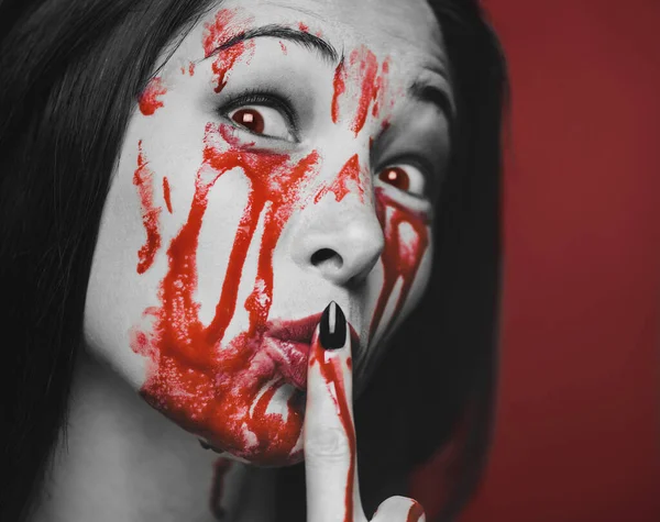 Horror woman in blood with shh silence gesture. — Stock Photo, Image