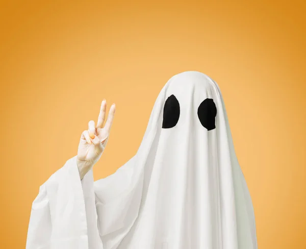 Halloween white ghost zeigt Peace-Zeichen-Geste auf gelbem Rücken — Stockfoto