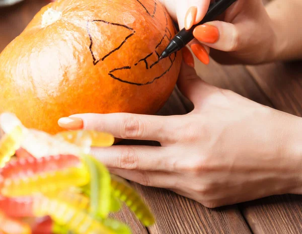 Woman drawing sketch face of jack-o-lantern on pumpkin, close-up — Stock Photo, Image
