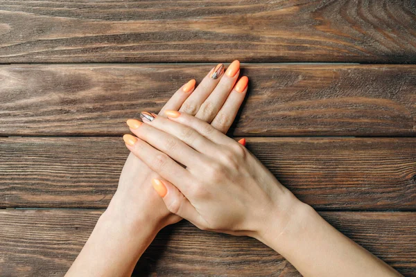 Vrouwelijke handen met professionele mooie manicure van oranje colo — Stockfoto