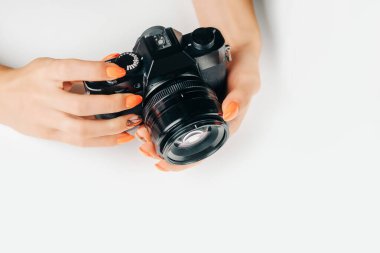 Genç bir kadının ellerinde fotoğraf makinesi var..