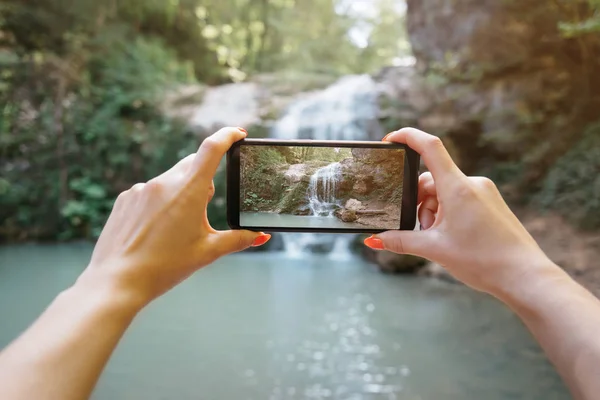 POV de manos tomando una foto de la cascada con el teléfono inteligente . — Foto de Stock