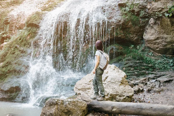 Explorador mujer mirando hermosa cascada en la naturaleza . — Foto de Stock