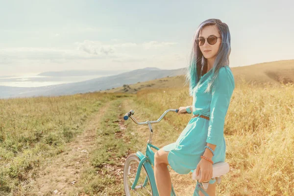 Mavi Saçlı Güzel Bir Kadın Yeşil Çayırlar Boyunca Bisiklet Üzerinde — Stok fotoğraf