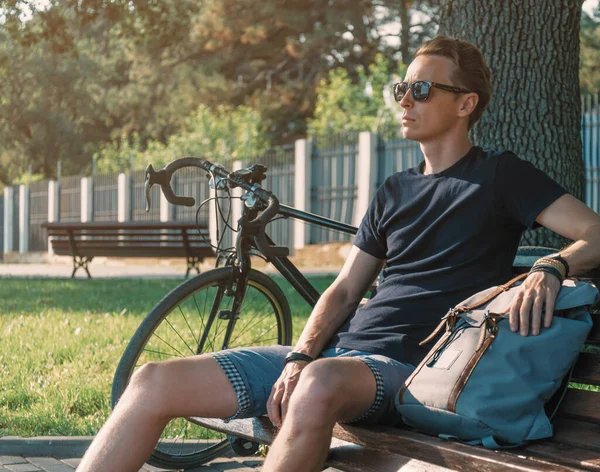 Elegante Chico Guapo Ciclista Descansa Banco Madera Con Mochila Cerca — Foto de Stock