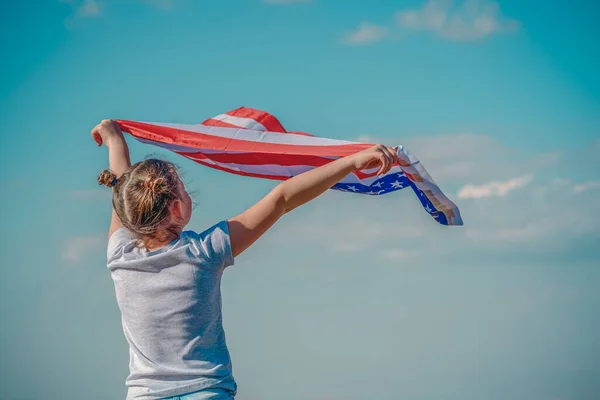 Hazafias ünnep. Boldog gyerek, aranyos kislány amerikai zászlóval. Az USA július 4-ét ünnepli. — Stock Fotó
