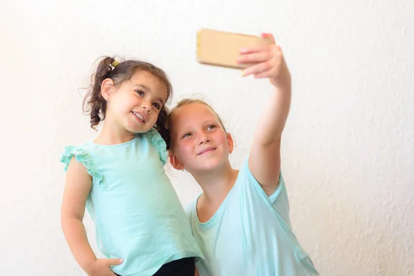Niños felices haciendo selfie.Two hermanas pequeñas adorables tomando fotos de sí mismo . — Foto de Stock