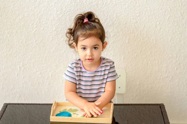 Дитяча творчість. Дитячі скульптури з глини. Мила маленька дівчинка форми з пластиліну на столі . — стокове фото