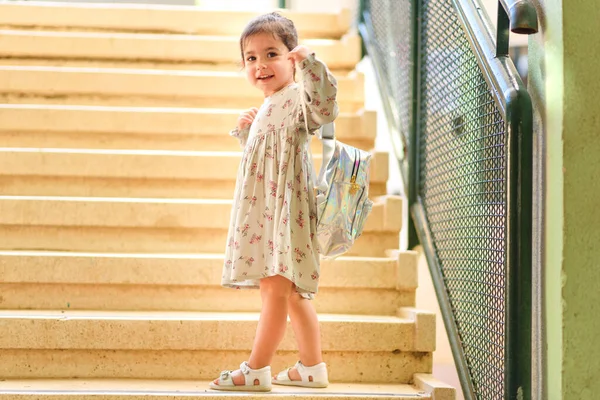 학교로 돌아가. 가방을 들고 즐거운 시간을 보내며 학교에 다니는 귀여운 어린 소녀. — 스톡 사진