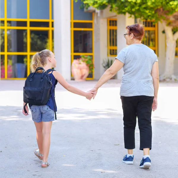 Bestemor Skoleelev Som Holder Hender Skolen Lita Jente Med Skolesekk – stockfoto