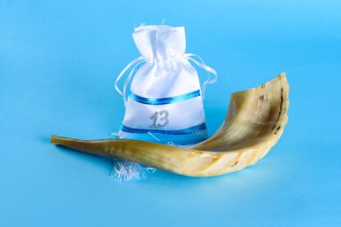 Shofar boynuzu ve bar mitzvah için hediye paketi. Tebrik kartı. Bir partiye davetiye. Yahudi çocuk 13 yaşına geldiğinde otomatikman Bar Mitzvah olur. Yan görünüm.