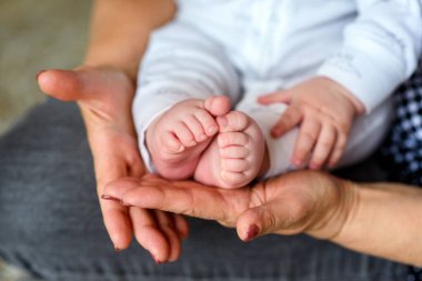 Torunu olan mutlu bir büyükanne. Son sınıf öğrencisi kadın şirin pembe bebek ayağını içeride tutuyor. Aile tatlı anları.