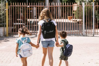 Mutlu okul çocukları güneşli bir günde açık havada okula gidiyorlar..