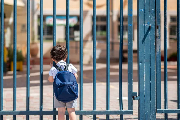 Kind mit Tasche zurück zur Schule. Gesichtsloser süßer kleiner Junge mit blauer Schultasche zurück in die Schule. Stockbild