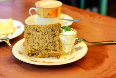 Güzel, taze bisküvi, krema ve nane yapraklarıyla ahşap bir masada servis edilen muhteşem çanak çömlek içinde..