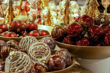 Noel süsleme baloları. Noel toplarının kırmızı ve altın rengi kasede. Noel ve Yeni Yıl Tatil Partisi için dekorasyon. Şenlikli, ışıklandırma arkaplanı