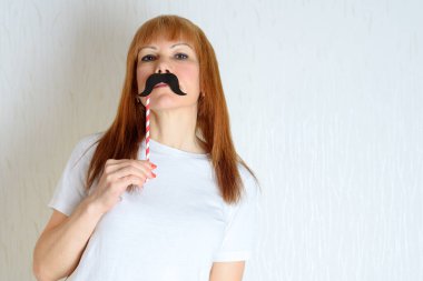Çekici, mutlu, orta yaşlı bir kadın sahte bir bıyıkla eğleniyor. Menopoza girmiş yaşlı bir kadın. Yaşam tarzı, Kadın Sağlığı konsepti: partiye hazır oyuncu olgun. Sahtekar sendromu.