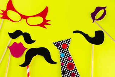 Komik maskeler, sakal, gözlük, bıyık, dudak, pipo ve sarı arka planda kravat. Parti, doğum günü, Cadılar Bayramı Babalar Günü, Purim, Aptal Günü konsepti..