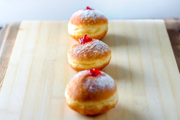 Close up view of tasty donuts with jam on wood background. Hanukkah celebration concept. — Stock Photo, Image