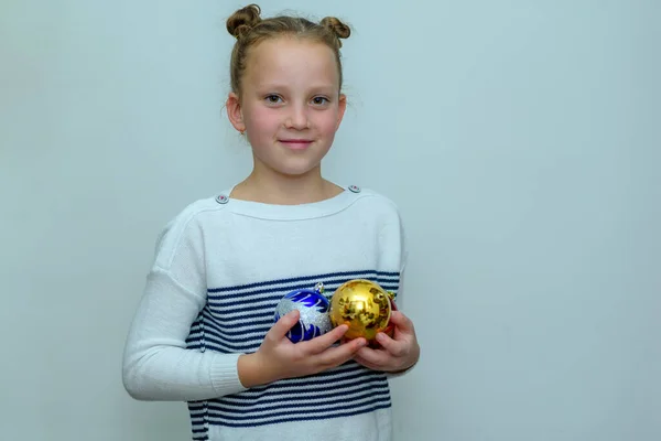 Mooie tiener meisje met haar broodje met kerstballen decoratie voor kerstboom. — Stockfoto