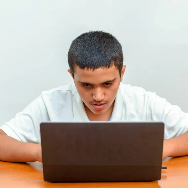 Teenager mit Laptop, der am Tisch sitzt und zu Hause lernt. Junger Geschäftsmann mit Laptop. — Stockfoto