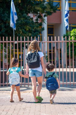 Mutlu okul çocukları güneşli bir sonbahar gününde açık havaya çıkıyorlar. İsrail 'de derslere başlıyorlar..