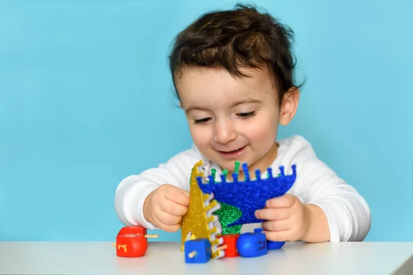 Єврейський хлопчик грає з дрейдлом і папером блискучі меню вдома.. — стокове фото