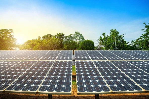 Módulos fotovoltaicos usina de energia solar e céu azul pôr do sol backg — Fotografia de Stock